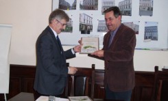 Wiceburmistrz Jan Zieliński przekazuje burmistrzowi Arseniuszowi Finsterowi przywiezione z Warszawy dyplomy.