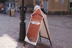 Potykacz na Starym Rynku wskazuje drogę do Informacji w Baszcie Nowa.