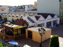Widok z ratuszowego balkonu na kompleks handlowo-usługowy przy narożniku rynku i Gimnazjalnej.