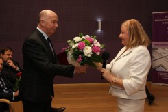 Dr Anna Struś odbiera kwiaty od dyrektora wydziału oświaty Janusza Ziarno.