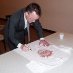 Jarosław Sellin podpisuje koszulkę chojnice24
